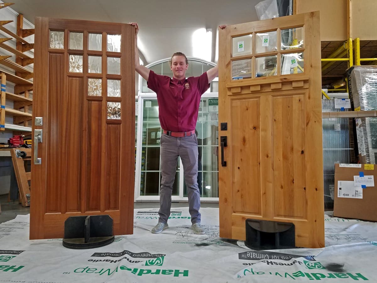 Josh carrying two Rogue Valley doors in our warehouse