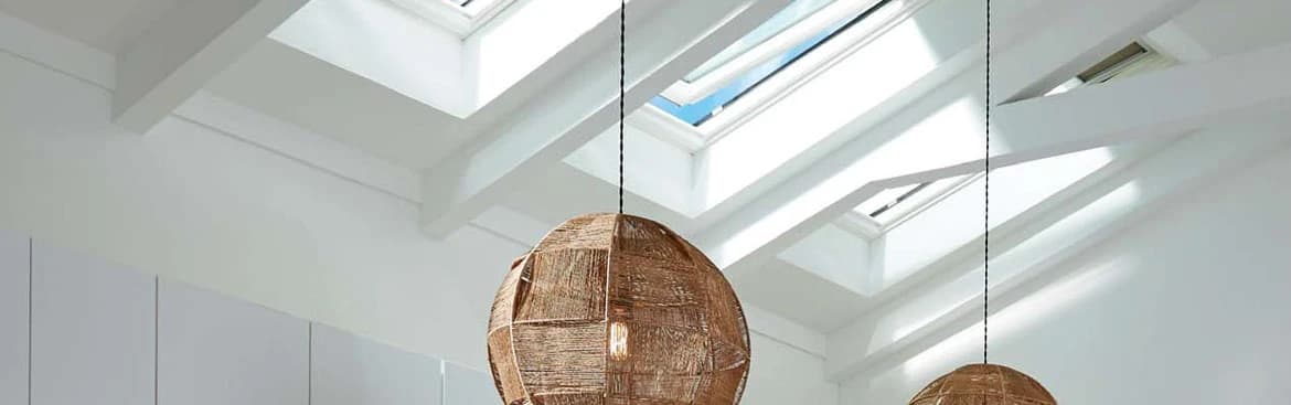 Two VELUX skylights in a white vaulted ceiling with woven pendant lights